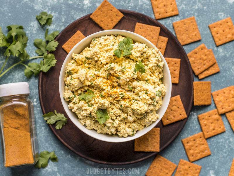 A bowl of Curried Tofu Salad surrounded by crackers