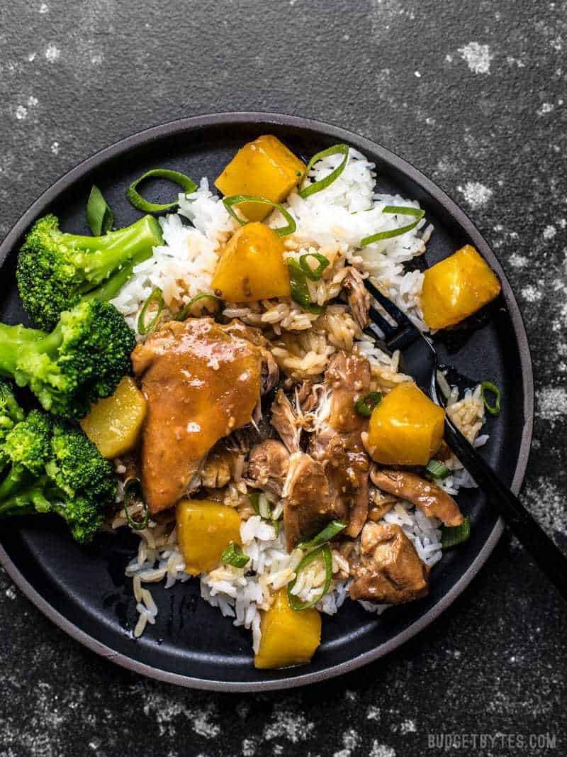 Slow Cooker Pineapple Teriyaki Chicken on a black stoneware plate with rice and broccoli