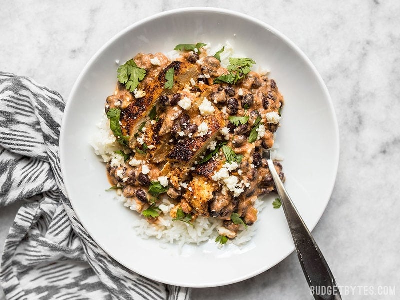 A bowl full of creamy salsa chicken skillet served over rice.