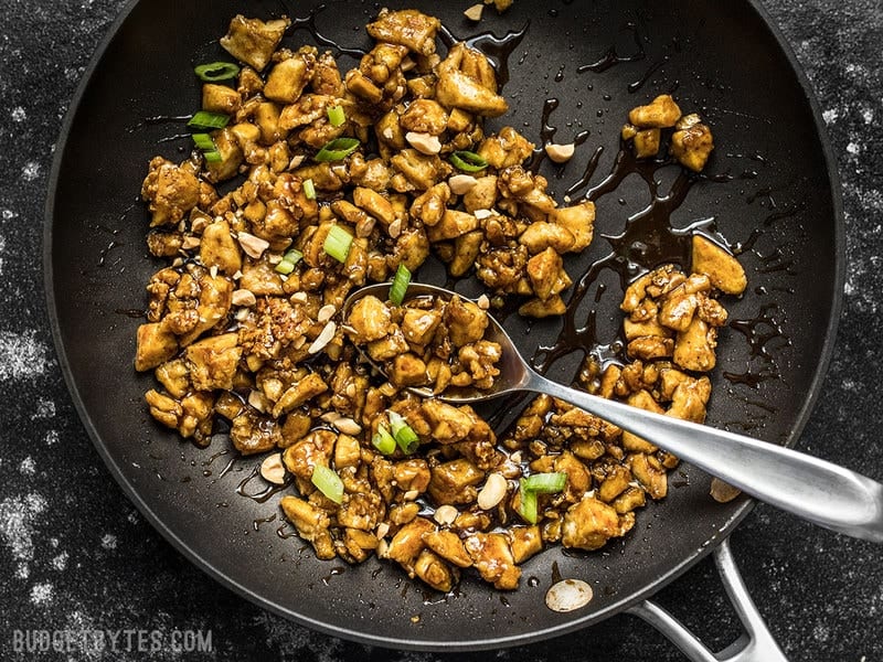 Hoisin Tofu mixture in the skillet with sauce and a spoon