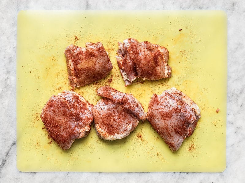 Seasoned Chicken Thighs on a cutting board