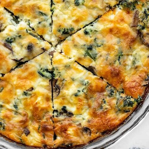 close up view of sliced spinach and mushroom crustless quiche in the pie dish