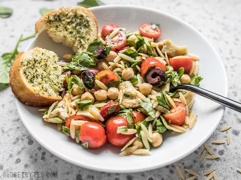 Front view of Italian Orzo Salad with a piece of garlic bread.