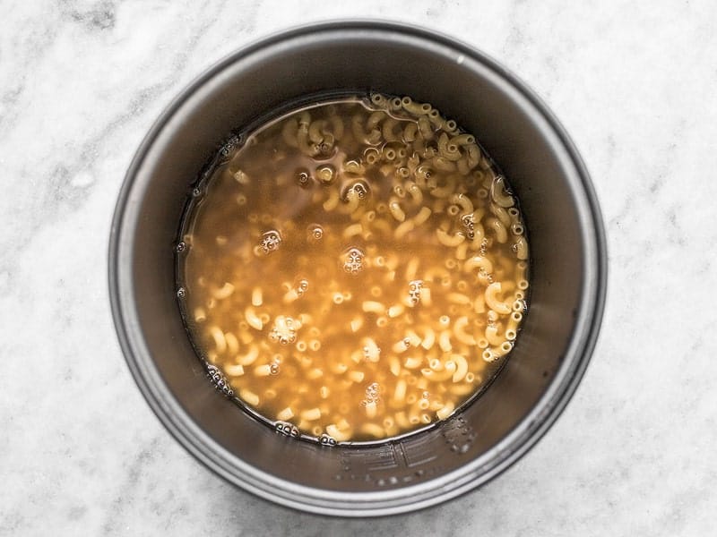 Add Macaroni and Vegetable Broth to Rice Cooker