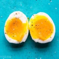 a soft boiled egg cut in half on a blue background