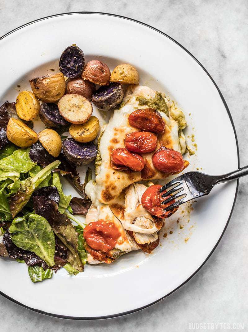 Sheet Pan Pesto Chicken Dinner close up and being eaten.