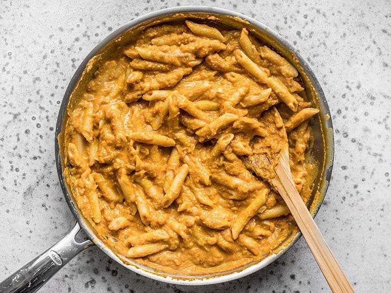 Finished Chipotle Pumpkin Pasta in the skillet with a wooden spoon