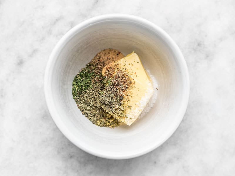 Garlic Herb Butter ingredients in a small white bowl