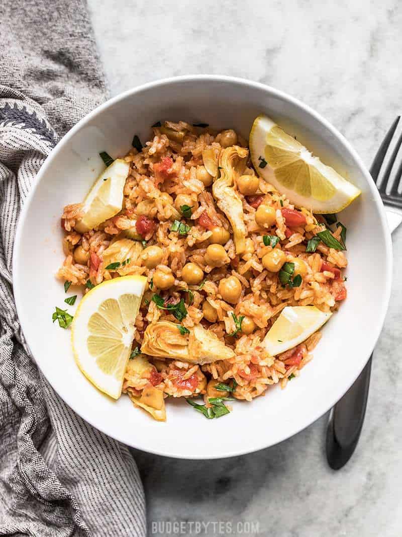 A hearty bowl of Rice Cooker Spanish Chickpeas and Rice with fresh lemon.