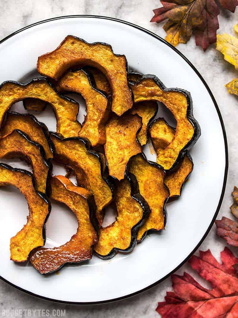 A plate full of Smoky Maple Roasted Acorn Squash on a holiday table.