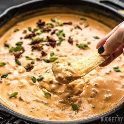 A chip scooping up Spicy Chorizo Cheese Dip