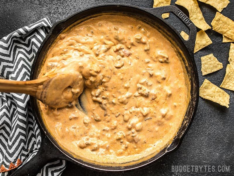 Thick Spicy Chorizo Cheese Dip being stirred in the skillet.