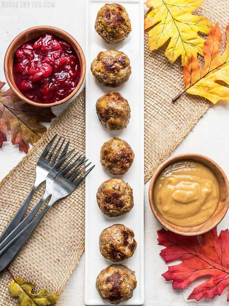 Thanksgiving appetizer spread with Turkey and Stuffing Meatballs, cranberry sauce, and gravy.