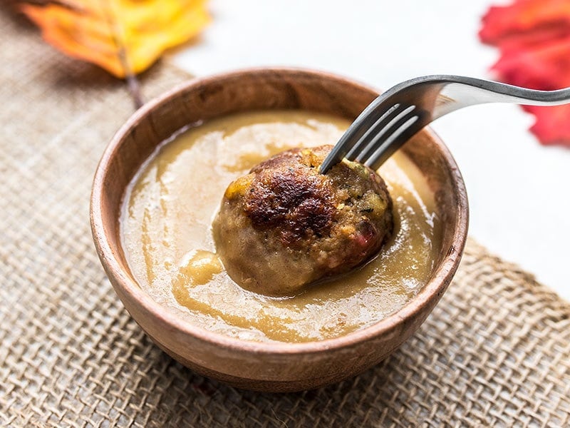 Turkey and Stuffing Meatballs being dipped into turkey gravy.