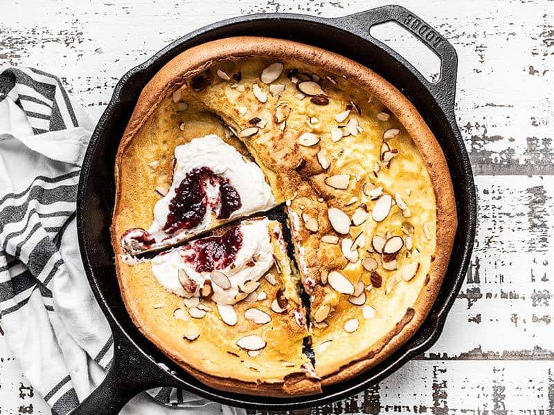 Almond Dutch Baby with Ricotta and Jam sliced and ready to serve