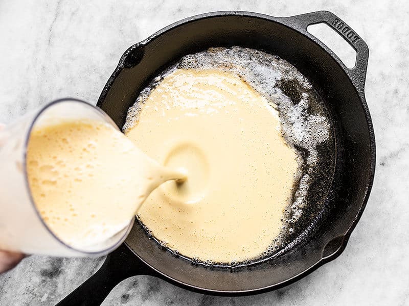 Pour Dutch Baby batter into hot skillet