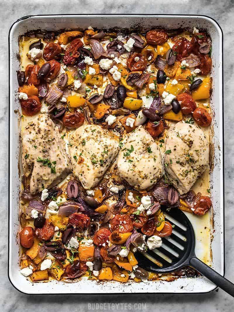 Sheet Pan Greek Chicken and Vegetables being served with a spatula.