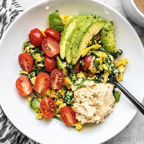 A large bowl of Vegetable Breakfast Scrambles about to be eaten with a fork.