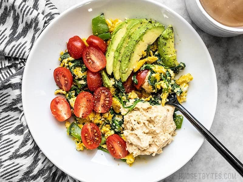 A large bowl of Vegetable Breakfast Scrambles about to be eaten with a fork.