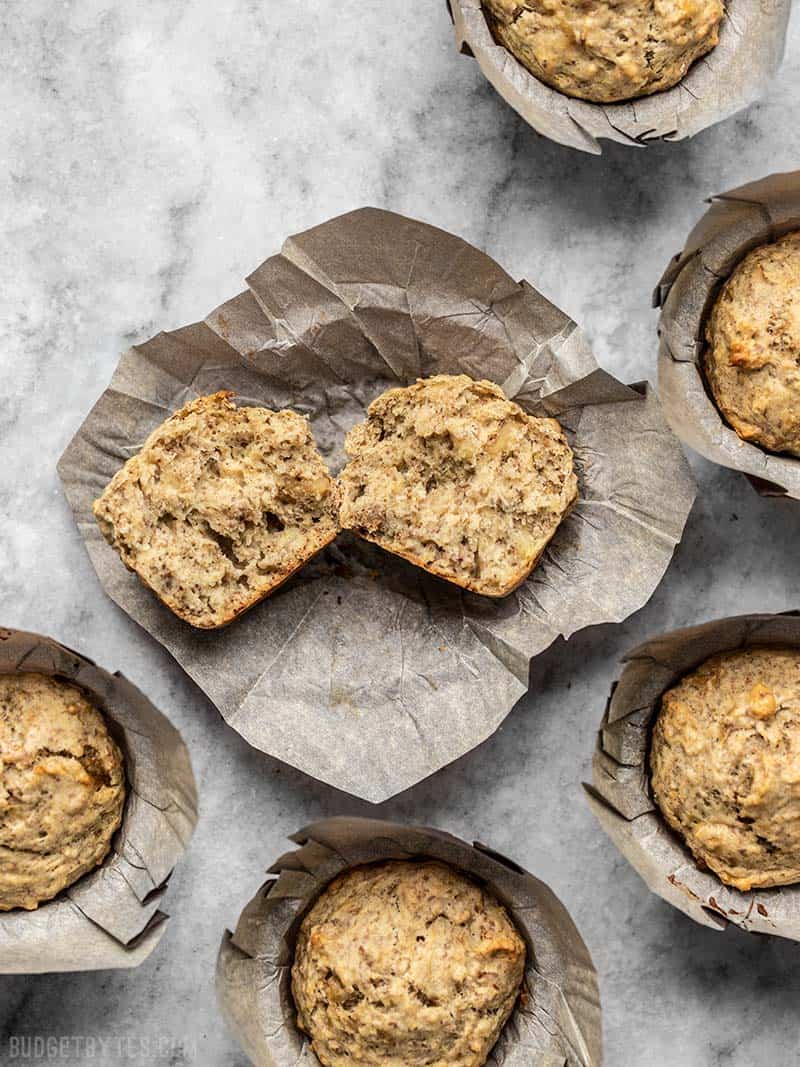 Banana Flax Muffins in paper liners, with one torn open