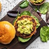 Cajun Salmon Burgers with guac from above on a cutting board