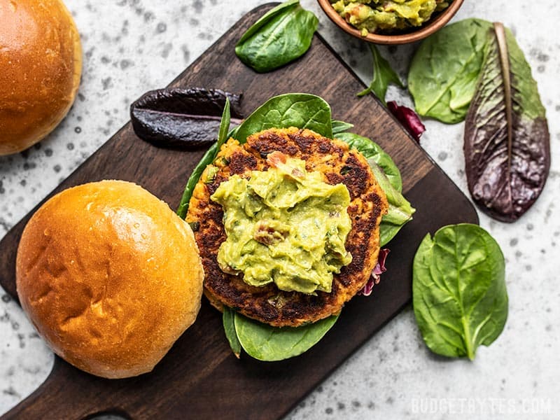 Cajun Salmon Burgers with guac from above on a cutting board