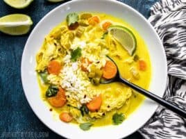 Coconut Turmeric Chicken Soup being eaten with rice and cilantro