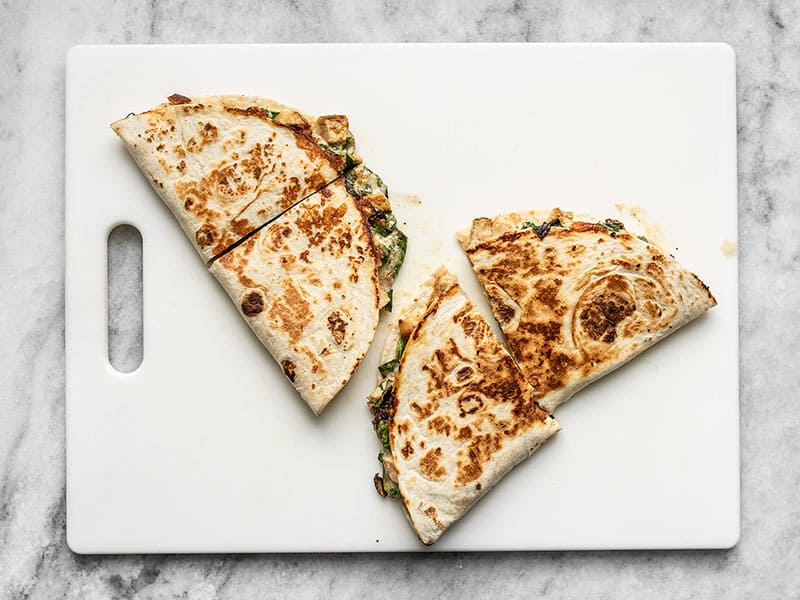 Quesadillas on a cutting board, cut in half