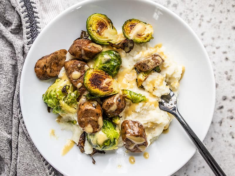 A Roasted Brussels Sprout Bowl being eaten with a black fork