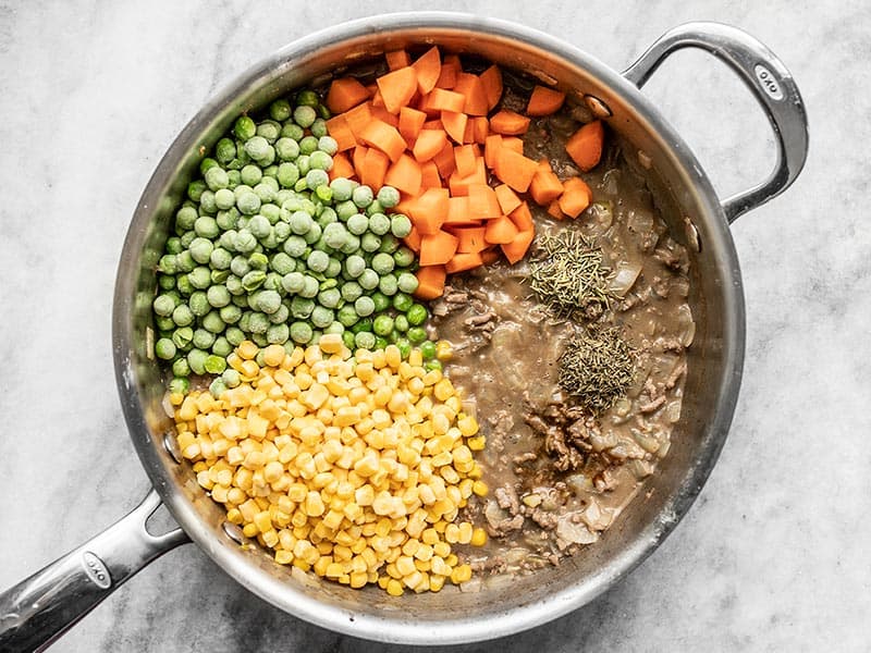 Add Vegetables Herbs and Spices to Beef and Gravy in the skillet