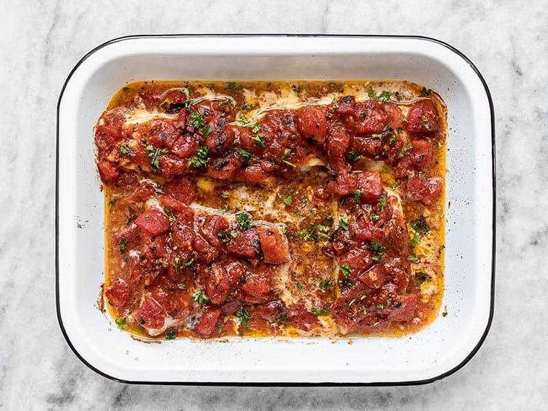 Baked fish with tomatoes in the baking dish