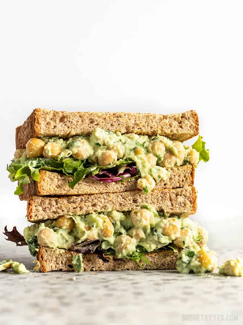 Two stacked halves of a Scallion Herb Chickpea Salad sandwich on wheat bread.