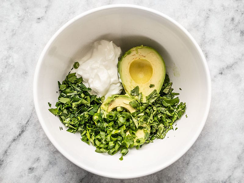 Ingredients for scallion herb avocado dressing in the bowl unmixed