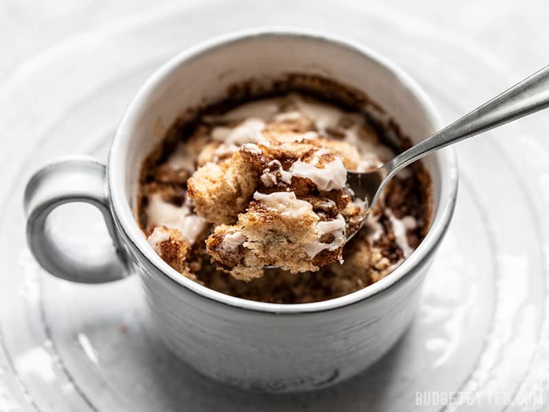 A spoonful of a Cinnamon Nut Swirl Mug Cake being lifted out of the mug.