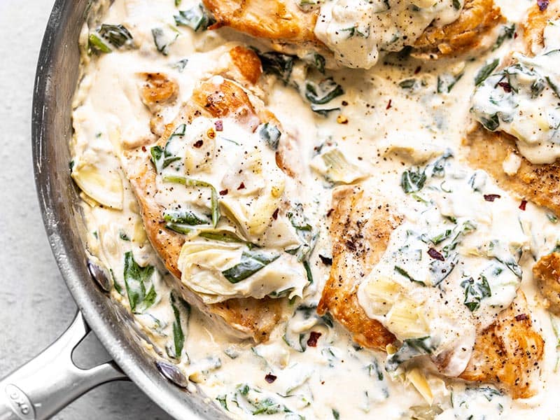 Close up overhead shot of Creamy Spinach Artichoke Chicken in the skillet. 