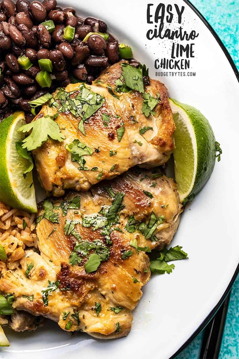 Cilantro lime chicken thighs on a plate with black beans and rice. Text overlay in the corner.