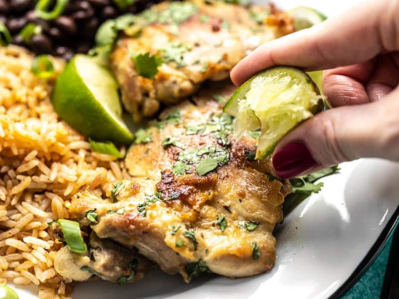 Close up of lime being squeeze over a piece of Easy Cilantro Lime Chicken