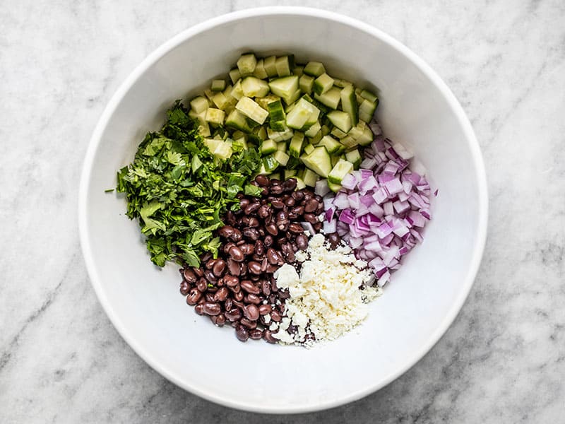 Cucumber and Black Bean Salad ingredients in a white bowl