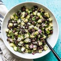 Cucumber and Black Bean Salad in a bowl with a black spoon