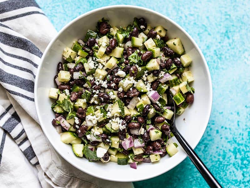 Cucumber and Black Bean Salad in a bowl with a black spoon