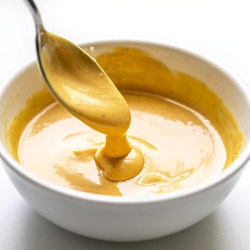 Honey Mustard Sauce dripping off a spoon into a bowl