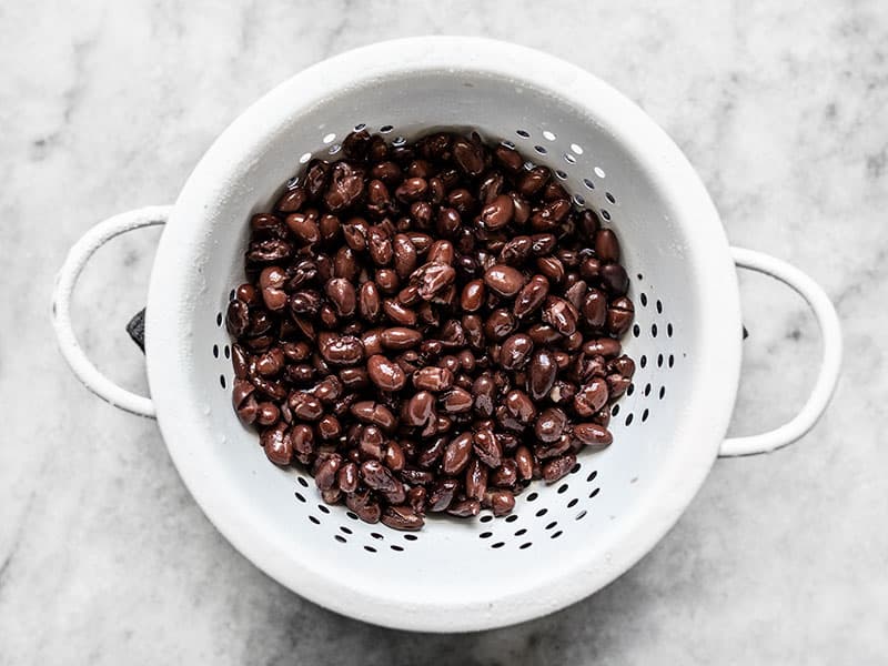 Rinsed and drained black beans in a white colander