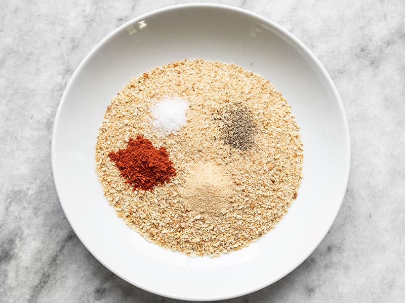 Breadcrumbs, smoked paprika, garlic powder, salt, and pepper in a shallow bowl