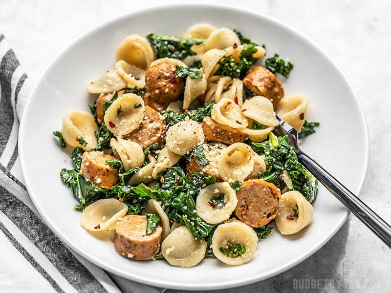 Front view of a shallow bowl full of Spicy Orecchiette with Chicken Sausage and Kale