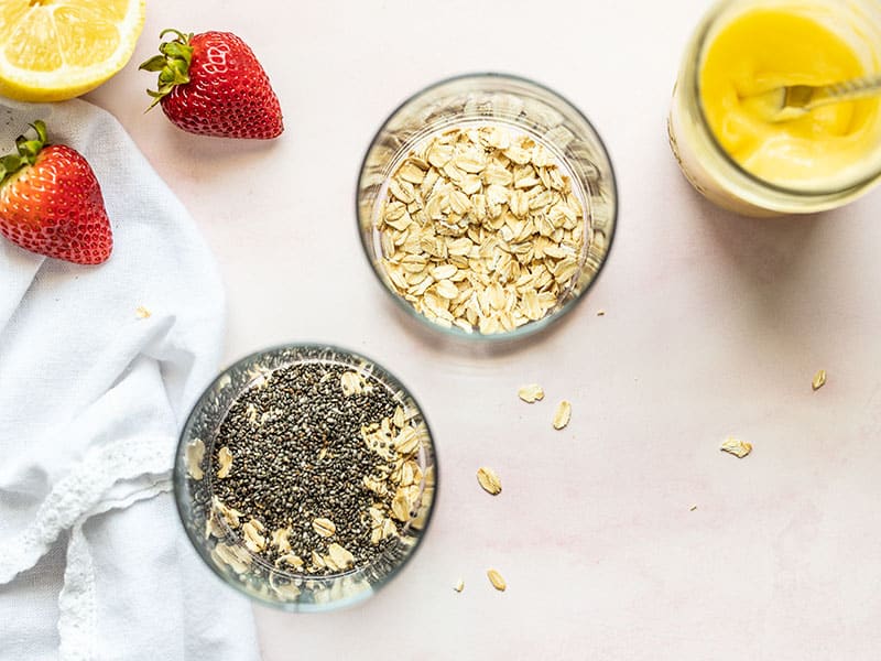 Oats and chia seeds layered in the bottom of two glasses.