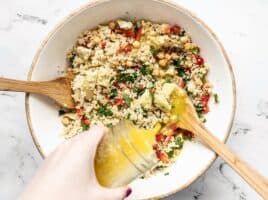 Lemon garlic dressing being poured over the salad bowl