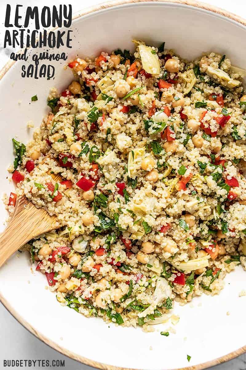 A big bowl of Lemony Artichoke and Quinoa Salad with title text overlay at the top