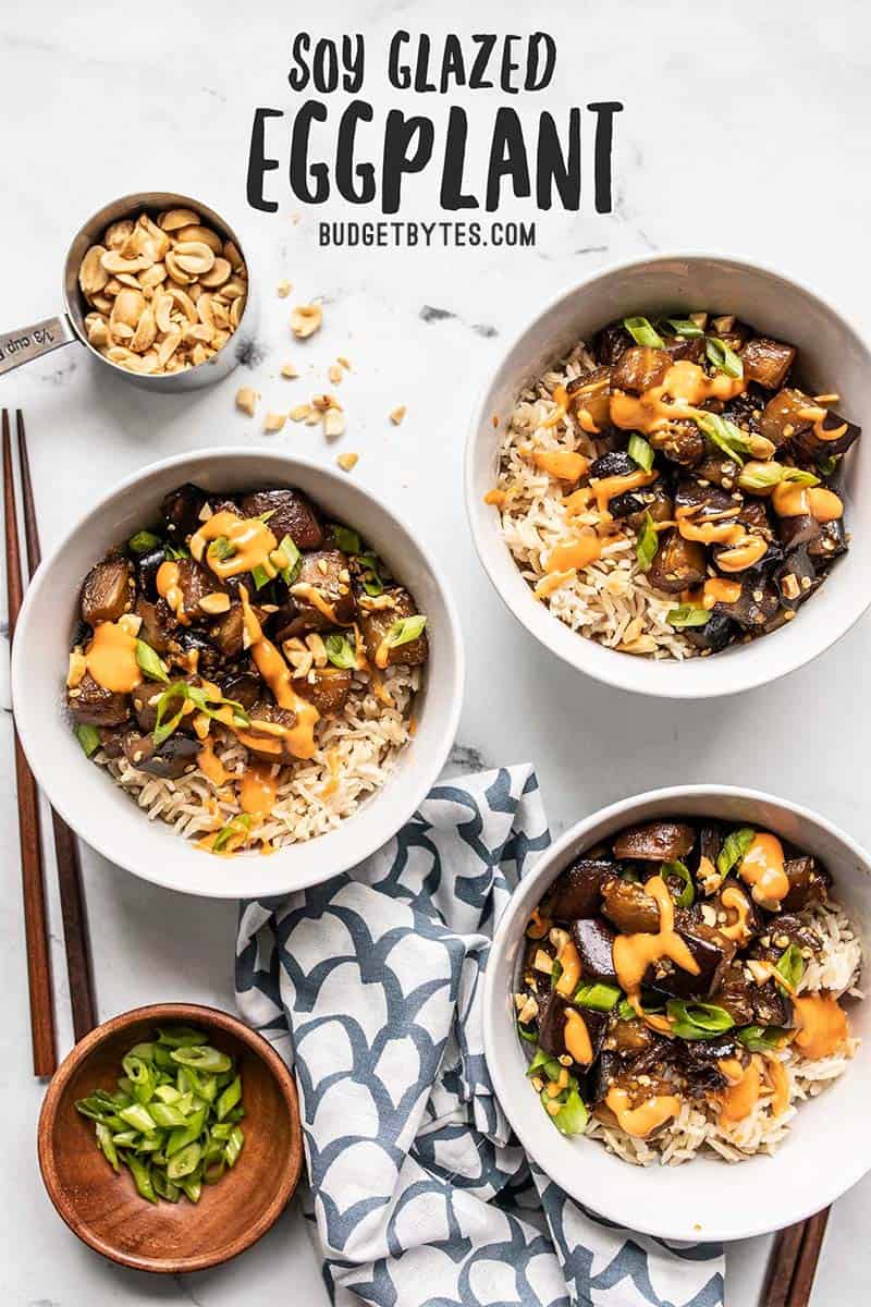 Three bowls of Soy Glazed Eggplant topped with sriracha mayo, peanuts, and green onion