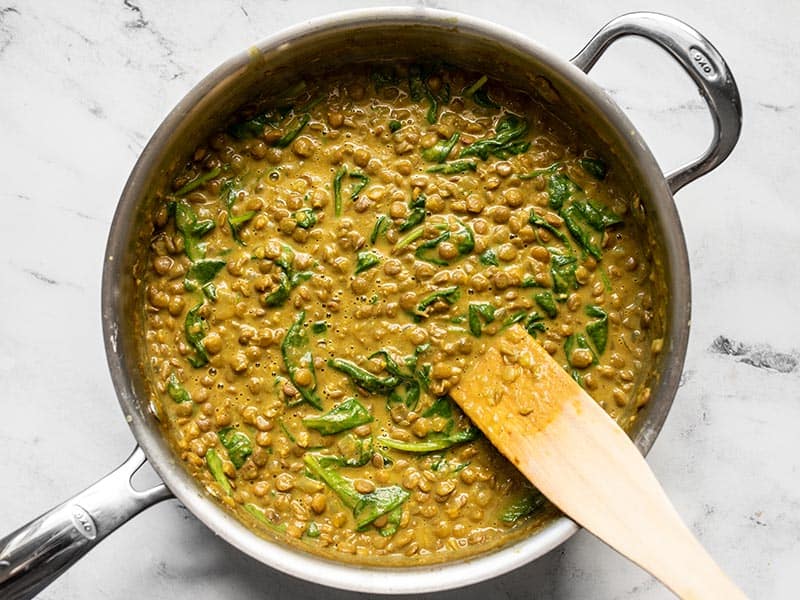 Spinach wilted into the coconut curry lentils