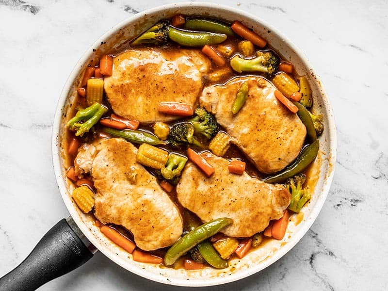 Pork Chops added back to the skillet with the vegetables and sauce.